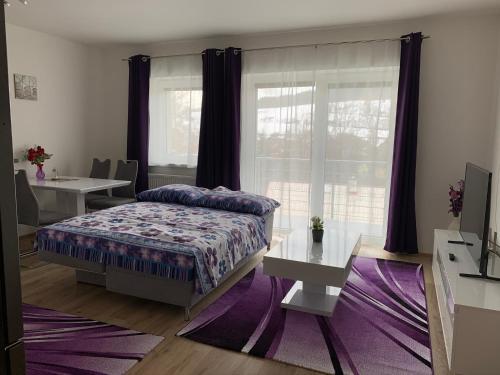 a bedroom with a bed and a purple rug at Apartmán s vyhlídkou in Horní Maršov