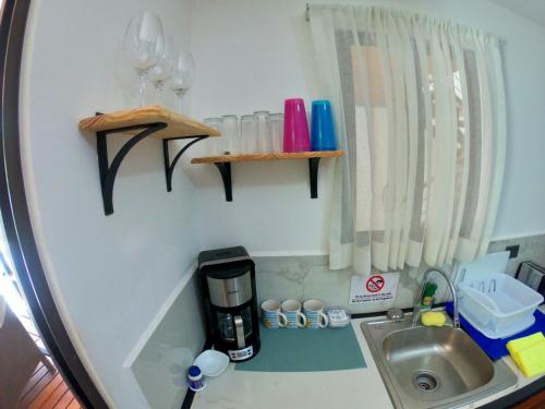 a small kitchen with a sink and a coffee maker at Shark Town Mal Pais in Santa Teresa Beach