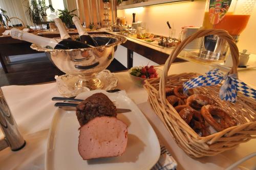 a table with a plate of bread and a basket of pretzels at Dom Hotel in Augsburg