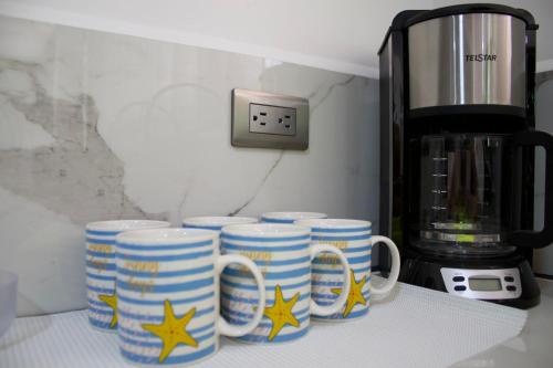 a group of coffee mugs sitting on a counter at Shark Town Mal Pais in Santa Teresa Beach