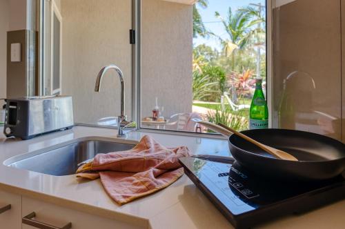Una cocina con un fregadero y una sartén sobre una encimera. en Noosa Sun - On the Noosa River, en Noosaville