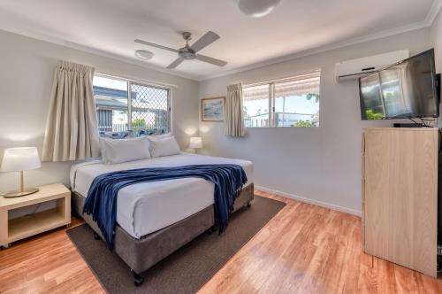 Un dormitorio con una cama y un televisor de pantalla plana. en Noosa Sun - On the Noosa River, en Noosaville