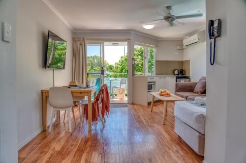 a living room filled with furniture and a kitchen at Noosa Sun Motel in Noosaville