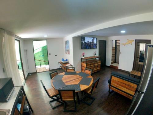 a living room with a dining room table and chairs at Shark Town Mal Pais in Santa Teresa Beach