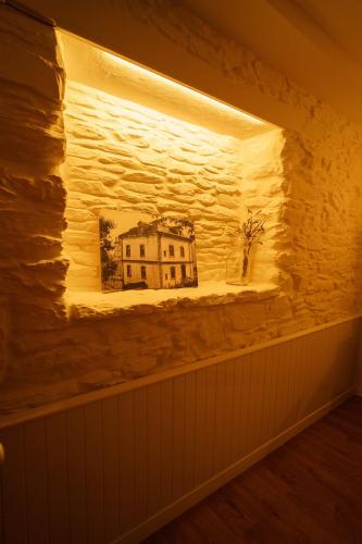a wall with a painting of a house on it at Apartamentos Minas de Silvarosa in Viveiro