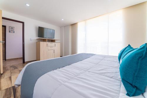 a bedroom with a bed with a television on the wall at Ayenda Boyaca VIP in Tunja