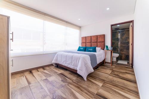 a bedroom with a bed and a large window at Ayenda Boyaca VIP in Tunja
