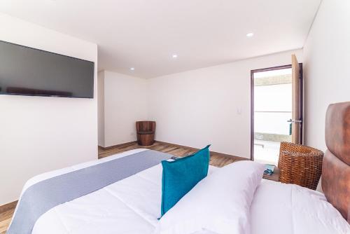a bedroom with a bed with a tv on the wall at Ayenda Boyaca VIP in Tunja
