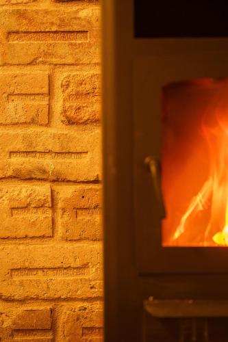 a brick wall with a fire in a fireplace at Apartamentos Minas de Silvarosa in Viveiro