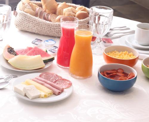 a table topped with plates of food and drinks at Guest House Guarujá Hotel Boutique in Guarujá