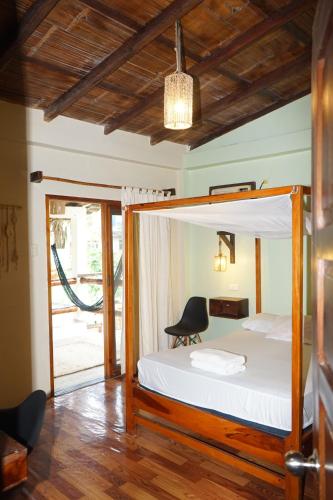 ein Schlafzimmer mit einem Bett und einem Stuhl darin in der Unterkunft Sapa Inka in Montañita