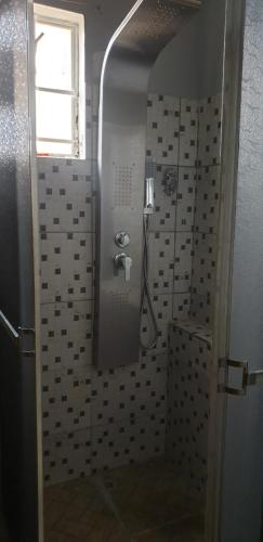 a bathroom with a shower with a sink and a window at Signature comfort in Arima