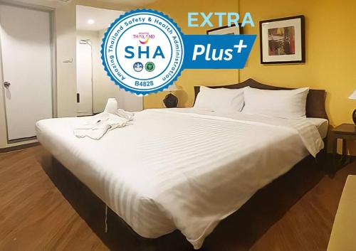 a large bed with a sign that says shha plus at Vinary Hotel Sukhumvit in Bangkok