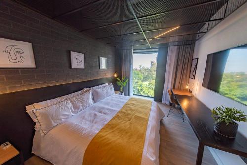 a bedroom with a bed and a large window at FULTON Business Luxury HOTEL in Guadalajara