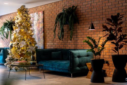 a living room with a green couch and a christmas tree at FULTON Business Luxury HOTEL in Guadalajara