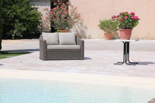 a chair sitting next to a table next to a pool at Mas Saint Julien in Cavaillon
