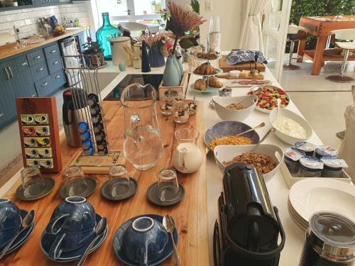 Long Story Guest House في بليتنبيرغ باي: طاولة مليئة بالأطباق وأوعية الطعام