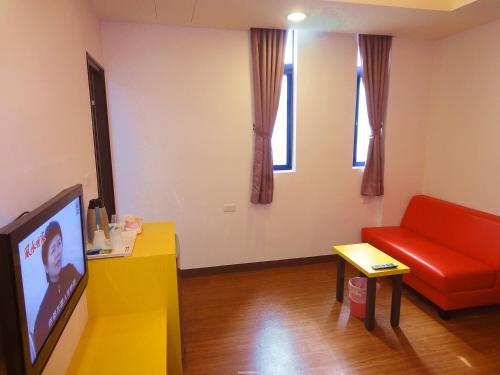 a living room with a red couch and a tv at Ship House in Xiaoliuqiu