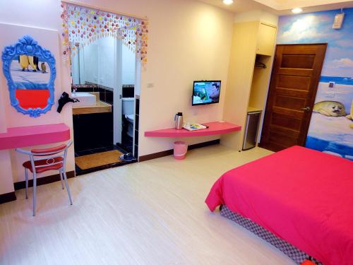 a bedroom with a red bed and a desk and a sink at Ship House in Xiaoliuqiu