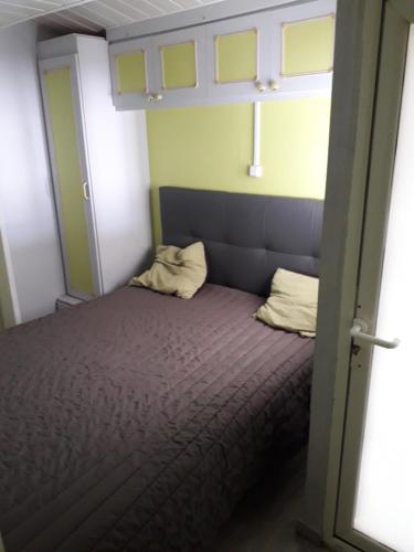 - un lit avec deux oreillers dans une petite chambre dans l'établissement Mobilhome, à Pornic