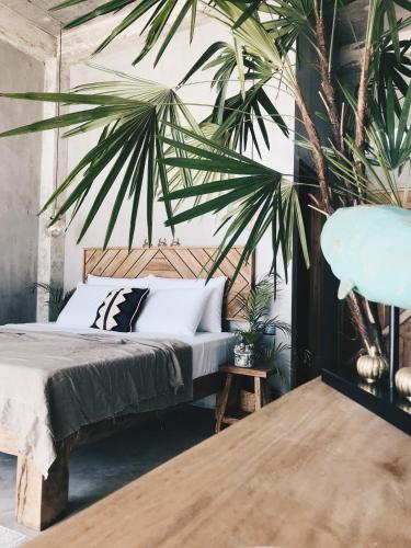 a bedroom with a bed and a palm tree at Morena Boutique Hotel Weligama in Midigama