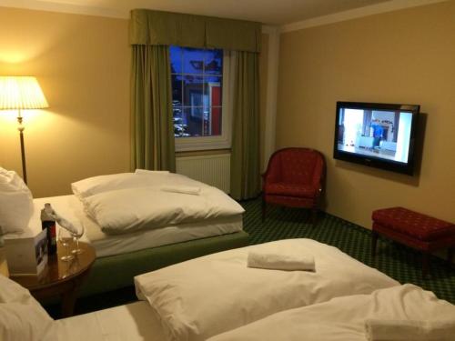 a hotel room with three beds and a flat screen tv at POD TĘŻNIĄ in Szczyrk