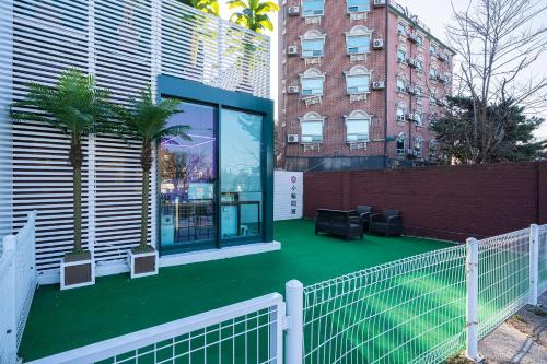 a house with a green floor in front of a building at Shourin Hotel Cheonan by Aank in Cheonan