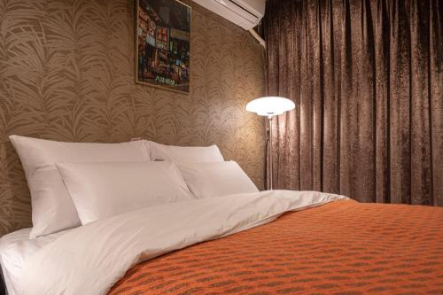 a bedroom with a bed with white pillows and a lamp at Shourin Hotel Cheonan by Aank in Cheonan