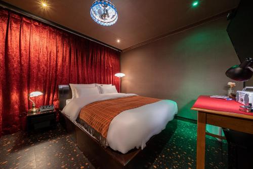 a bedroom with a bed and a red curtain at Shourin Hotel Cheonan by Aank in Cheonan