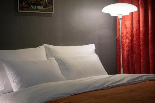 a bed with white pillows next to a lamp at Shourin Hotel Cheonan by Aank in Cheonan