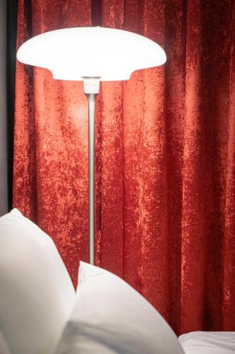 a white lamp in front of a red curtain at Shourin Hotel Cheonan by Aank in Cheonan