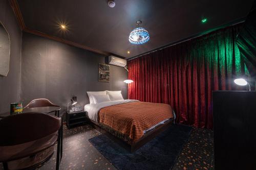 a bedroom with a bed and a red curtain at Shourin Hotel Cheonan by Aank in Cheonan