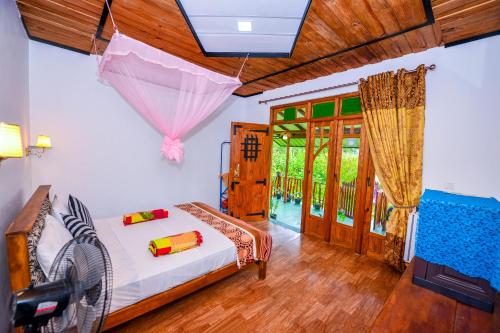 a bedroom with a bed with an umbrella on it at Astral Zone Cottage ELLA in Ella