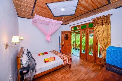 a bedroom with a bed with an umbrella hanging from the ceiling at Astral Zone Cottage ELLA in Ella