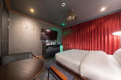 a bedroom with a bed and a table in a room at Shourin Hotel Cheonan by Aank in Cheonan