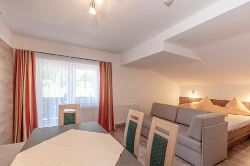 a room with a bed and a table and a couch at Apart Felsenhof in Längenfeld