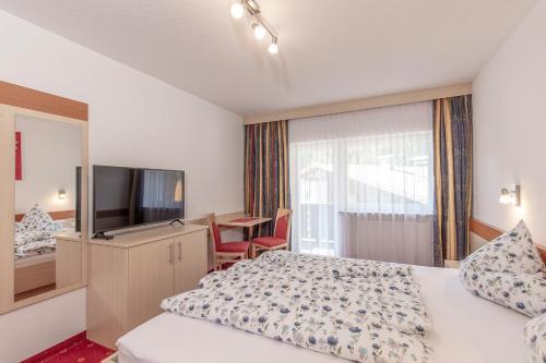 a hotel room with a bed and a television at Apart Felsenhof in Längenfeld