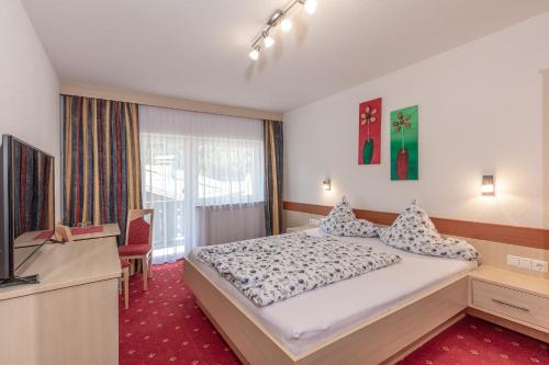 a hotel room with a bed and a television at Apart Felsenhof in Längenfeld