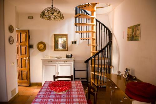 a dining room with a table and a spiral staircase at La Turr De Mezz in Nesso