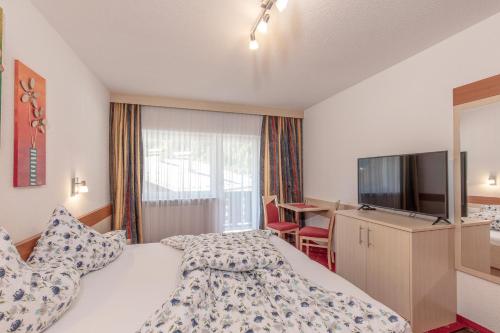 a hotel room with a bed and a flat screen tv at Apart Felsenhof in Längenfeld