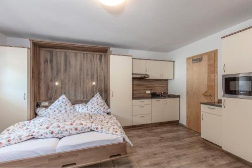 a small bedroom with a bed and a kitchen at Apart Felsenhof in Längenfeld