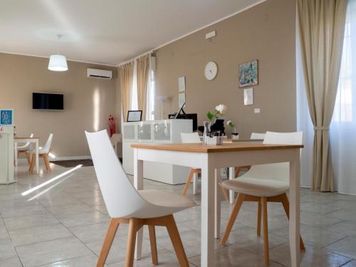 a dining room with a table and white chairs at Villa Paestum in Paestum