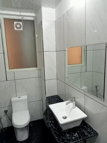 a bathroom with a toilet and a sink and a mirror at Divy Villa in Jaipur