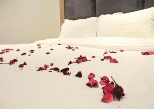 a pile of red roses on a bed at بست نايت للاجنحة الفندقية in Jeddah