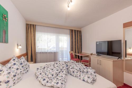 a hotel room with a bed and a television at Apart Felsenhof in Längenfeld