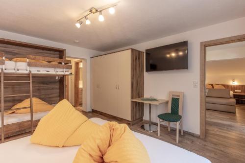 a bedroom with a bunk bed and a living room at Apart Felsenhof in Längenfeld