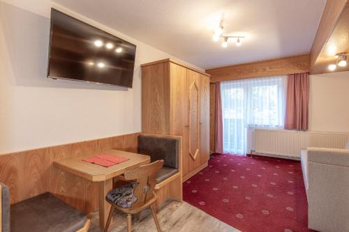 a room with a table and a television on the wall at Apart Felsenhof in Längenfeld