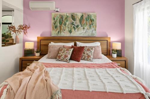 a bedroom with a large white bed with pillows at Villa Blue - Coastal Family Escape in Palm Cove