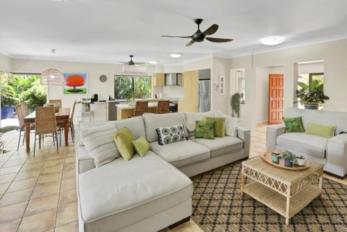 a living room with a white couch and a table at Villa Blue - Coastal Family Escape in Palm Cove
