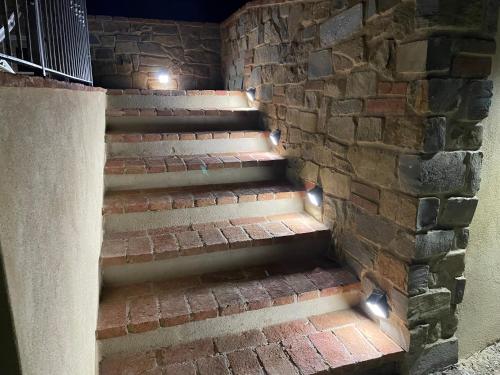 a brick stairway with lights in a brick wall at Casa Bici in Chianni